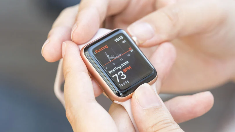 Persoana isi masoara pulsul folosind Apple Watch