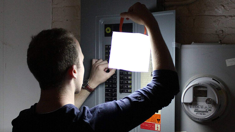 Persoana foloseste panoul electric de sigurante
