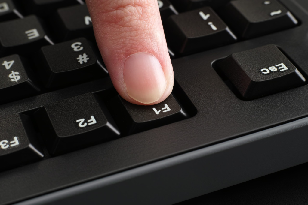 Persoana apasa pe tastatura tasta functionala F1