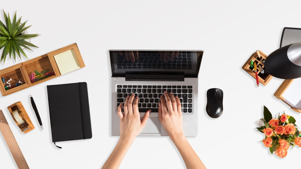 Persoana creeaza un blog folosind un laptop