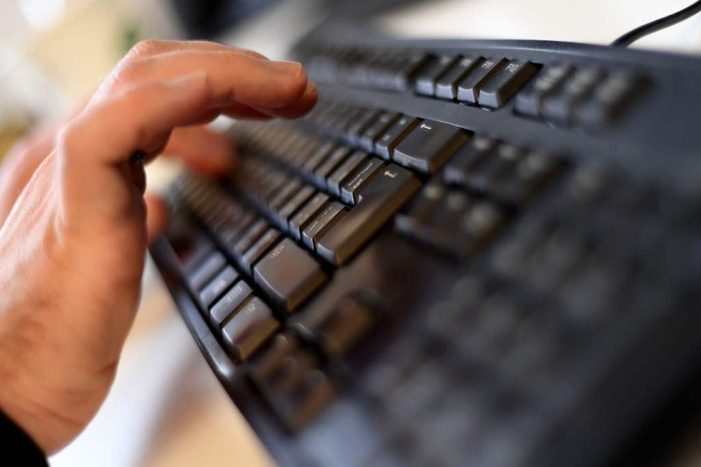 Persoana folosind scurtaturile pe o tastatura