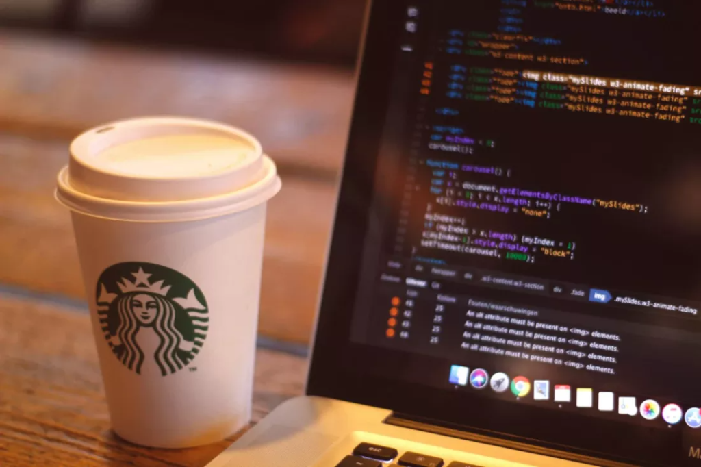 Cafea Starbucks langa un laptop de munca