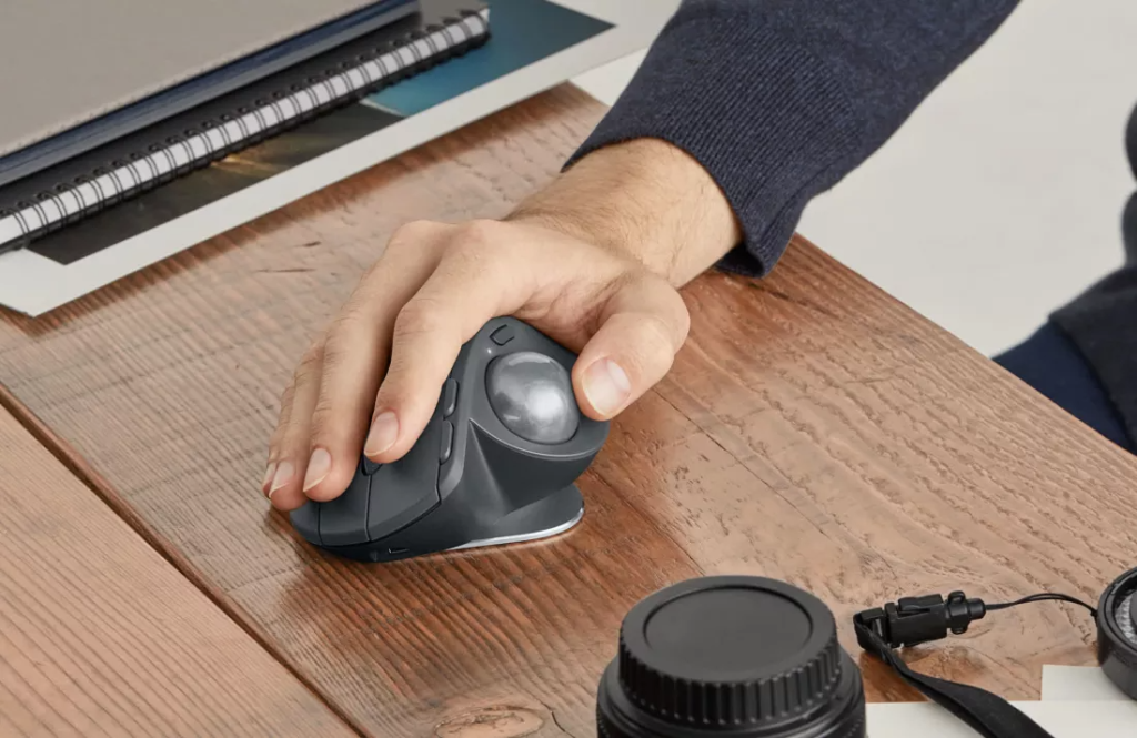 Persoana foloseste la birou un mouse ergonomic cu trackball
